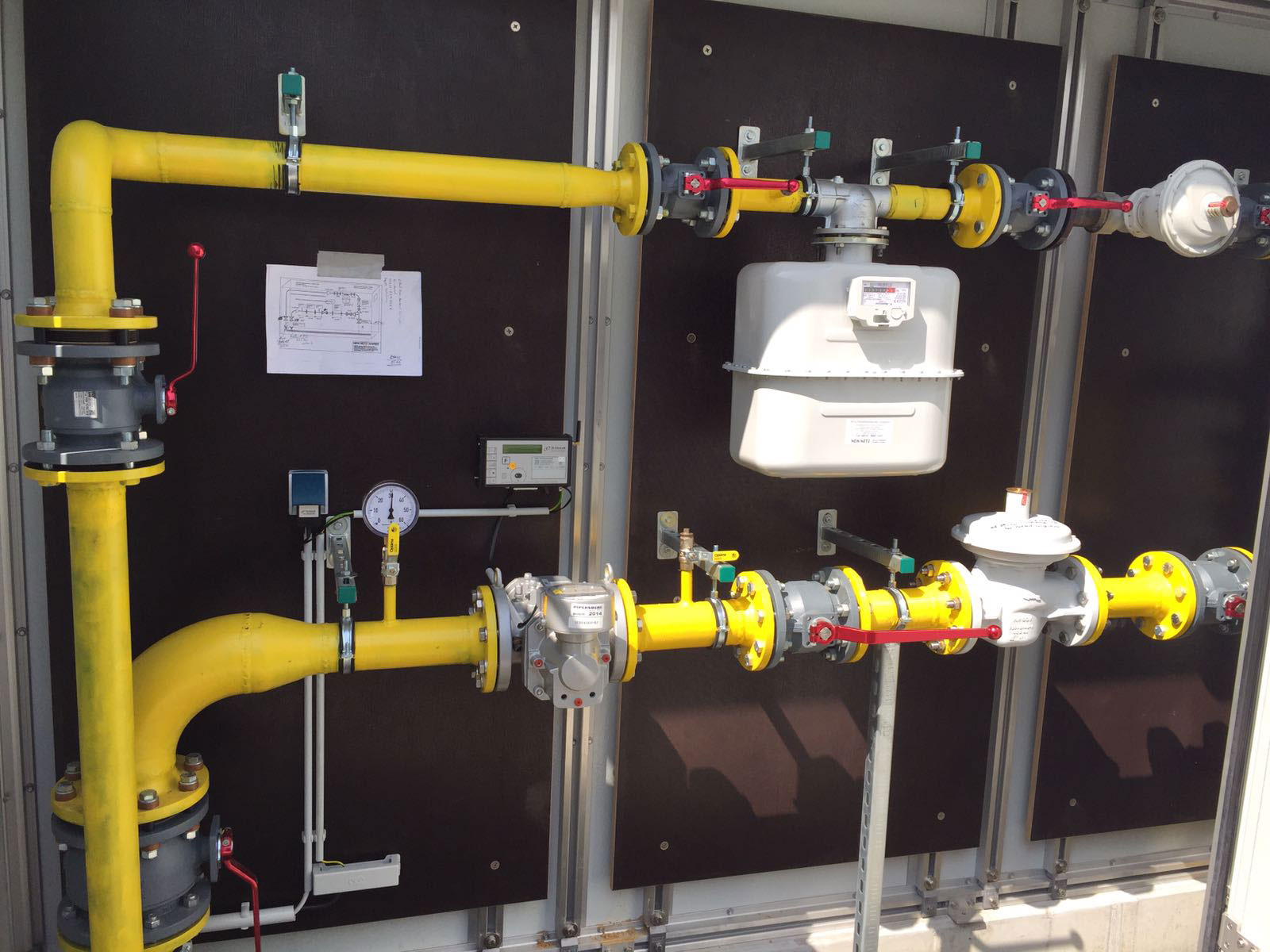 Gelbe Gasleitung mit Mess- und Regeltechnik in einem Technikraum.