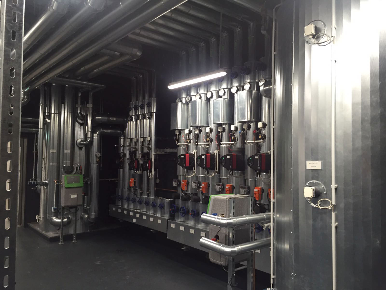 Industrielle Rohrverteilung mit Ventilen und Messgeräten in einer Energie- oder Heizungsanlage.
