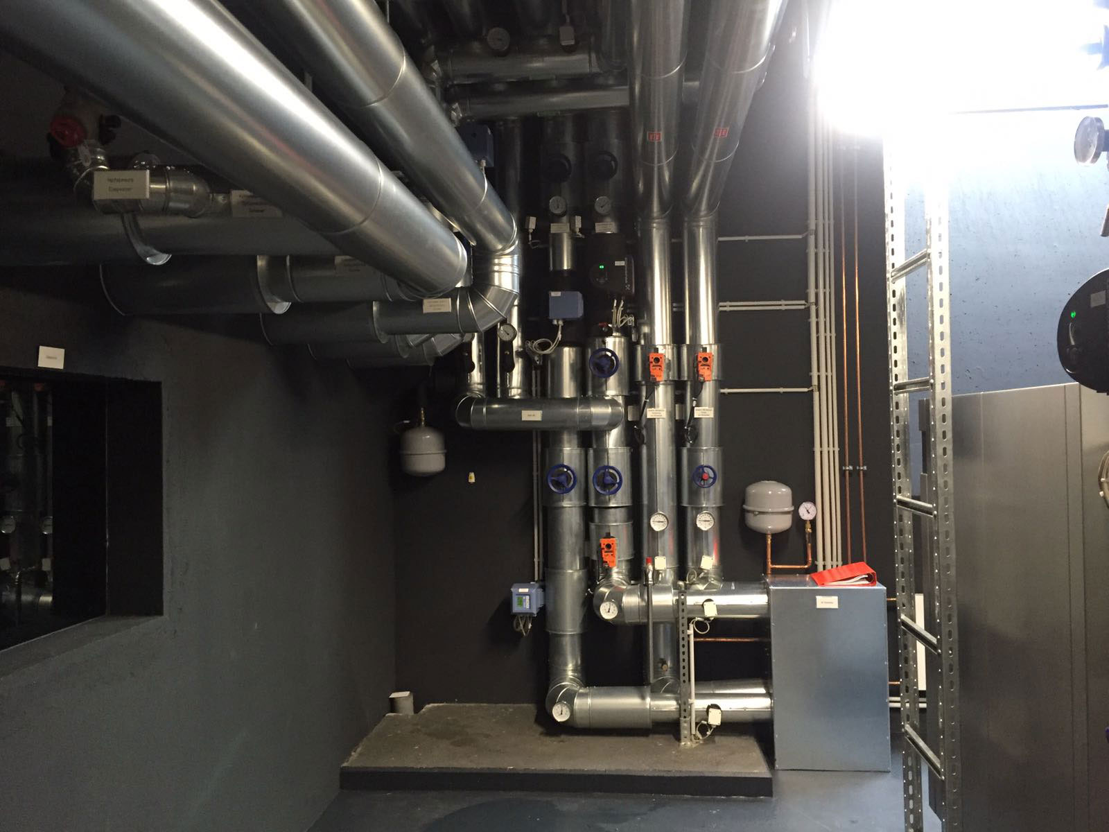 Rohrleitungen und Ventile einer industriellen Heizungs- oder Energieanlage im Technikraum.